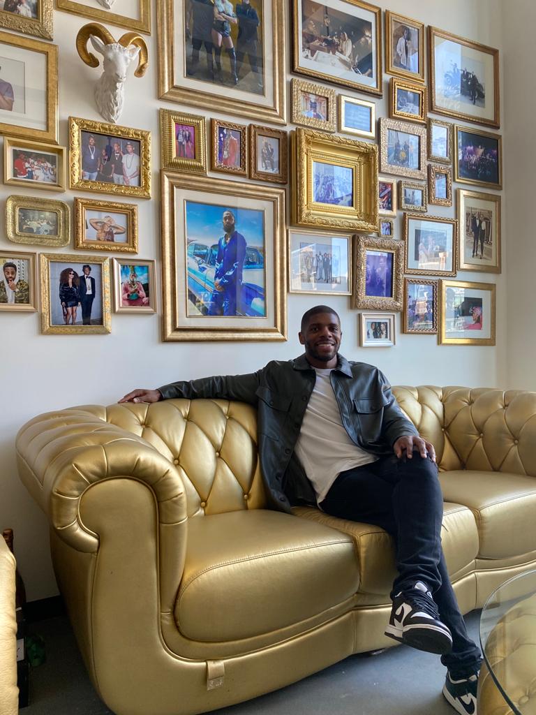 Paul Adesoye seated on a sofa